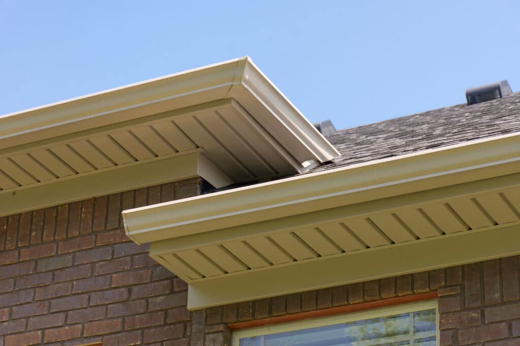 Roof showing gutters and soffit on the back of a brick house.